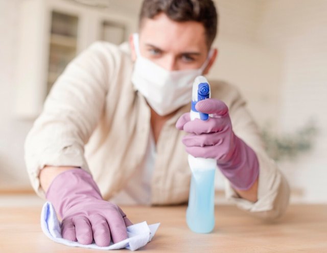 man-disinfecting-wooden-table_23-2148563318.jpg