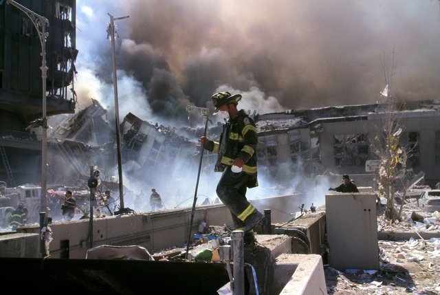 Fire_fighters_amid_smoking_rubble_after_September_11th_terrorist_attack_(29392249476).jpg