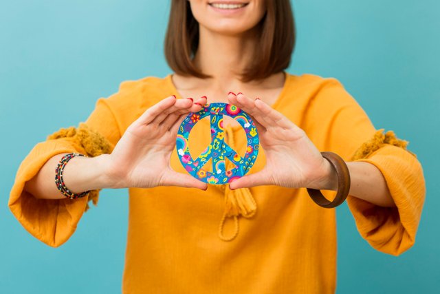 front-view-of-smiley-woman-holding-peace-sign.jpg