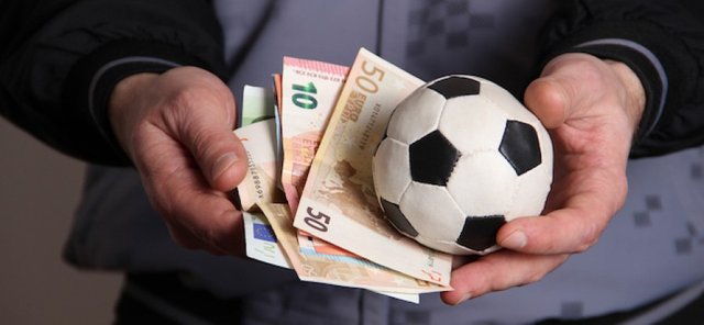 Man_holding_football_and_money_in_his_hands_036b7872a2faa2e89bf46c508f80e549.jpg