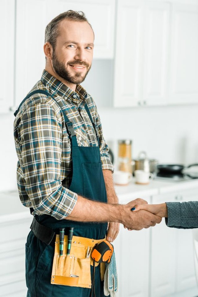 stock-photo-smiling-handsome-plumber-customer-shaking.jpg