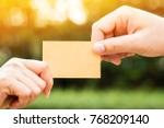 stock-photo-woman-hand-giving-a-gift-voucher-or-a-business-cards-to-customer-or-partners-on-bokeh-background-in-768209140.jpg