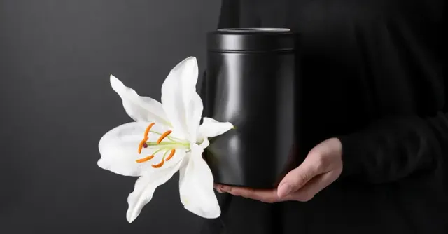 14138-woman-holding-cremation-urn-with-white-lily-f.webp