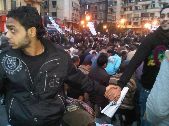 8. Christians protect Muslims during prayer in the midst of the 2011 uprisings in Cairo, Egypt.jpg