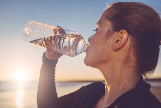 woman-drinking-water-seaside--511066579-5a1f4494beba3300374c63a3.jpg