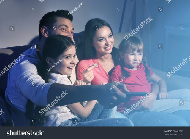 stock-photo-happy-family-watching-tv-on-sofa-at-home-604416272.jpg