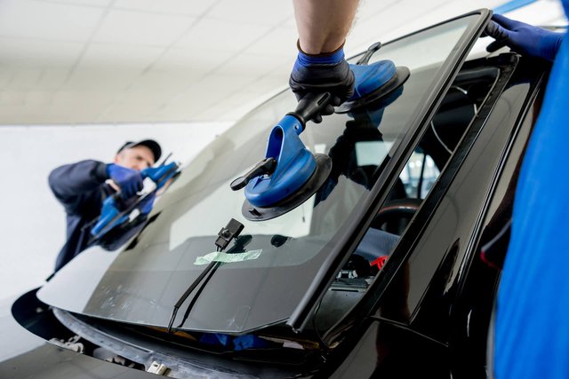 Automobile-special-workers-replacing-windscreen-or-windshield-of-a-car-in-auto-service-station-garage.-Background.jpg