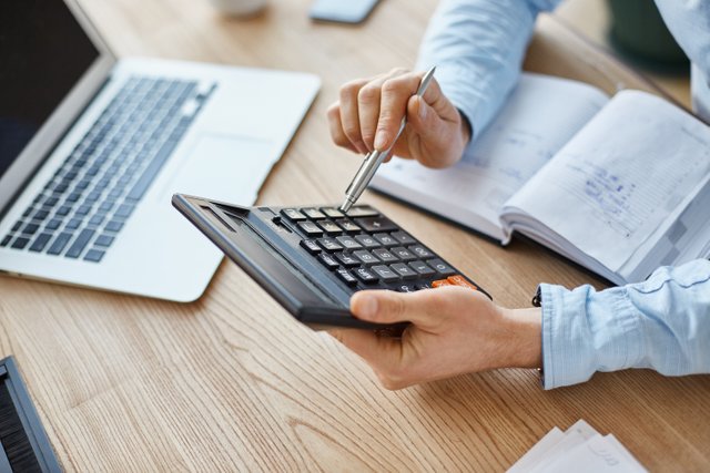 cropped-view-professional-serious-finance-manager-holding-calculator-hands-checking-company-month-s-profits (1).jpg