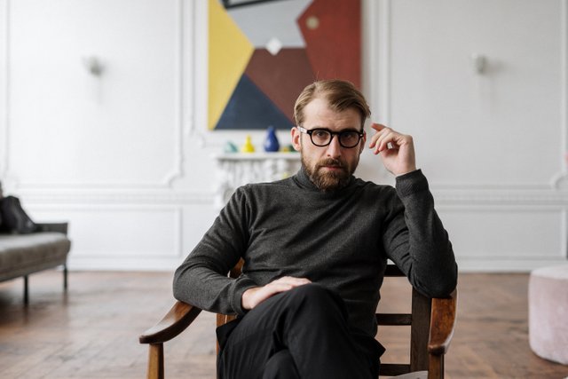 man-in-black-sweater-sitting-on-brown-wooden-chair-4100672.jpg