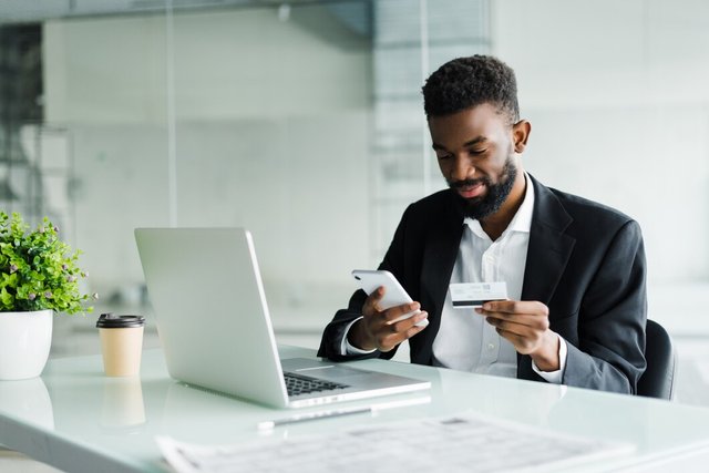 african-american-man-paying-with-credit-card-online-while-making-orders-via-mobile-internet-making-transaction-using-mobile-bank-application_231208-739.jpg