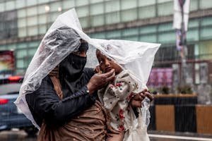 free-photo-of-woman-with-child-under-plastic-cover-during-rain.jpeg