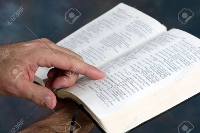 5645502-man-holds-open-bible-and-reads-from-scripture-.jpg