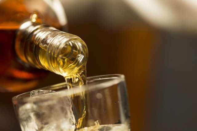 whiskey being poured into a glass