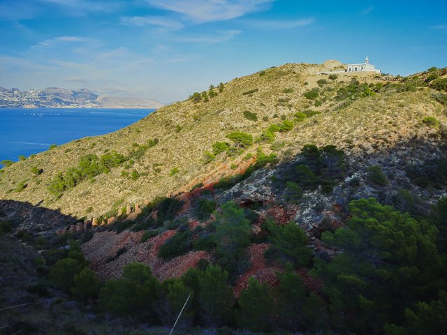   After a few couples of hundred meters, deep in the cove, iron-rich red stones of La Mina (eng. Mine) appear right into your face. This ochre mine was run by a single family from the mid-19th to early 20th century. Photo by Alis Monte [CC BY-SA 4.0], via Connecting the Dots