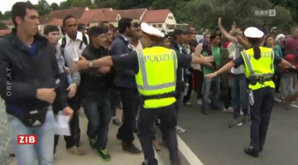 Flüchtlinge ignorieren den hilflosen Versuch der österreichischen Polizei, eine Pass-Kontrolle durchzuführen. (Screenshot ORF)