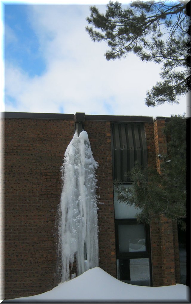 brick wall on school showing large mass of icicles coming from downspout.JPG