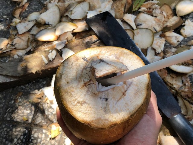 Breaking the coconut shell to insert a straw