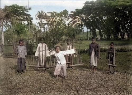 Bocah bermain angklung, 1880. Stoop. Colorized..jpg