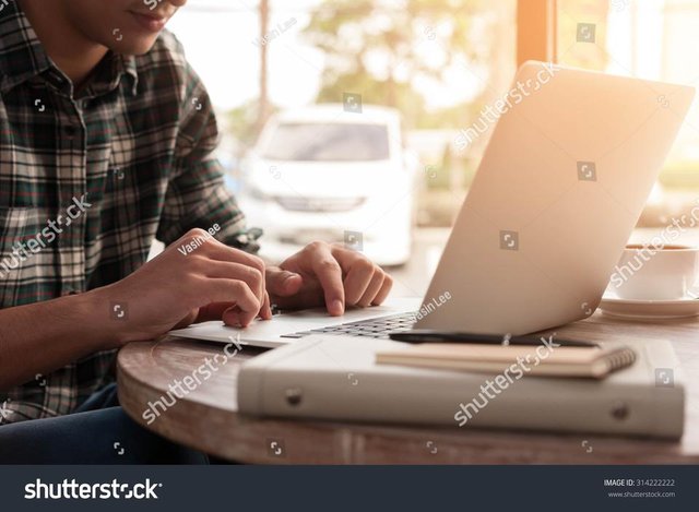 stock-photo-businessman-using-laptop-with-tablet-and-pen-on-wooden-table-in-coffee-shop-with-a-cup-of-coffee-314222222.jpg