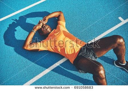 stock-photo-tired-young-athletic-african-man-in-sportswear-lying-on-the-lanes-of-a-running-track-taking-a-break-691058683.jpg