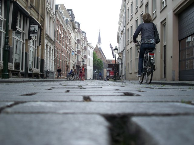 Woman rides bike down street