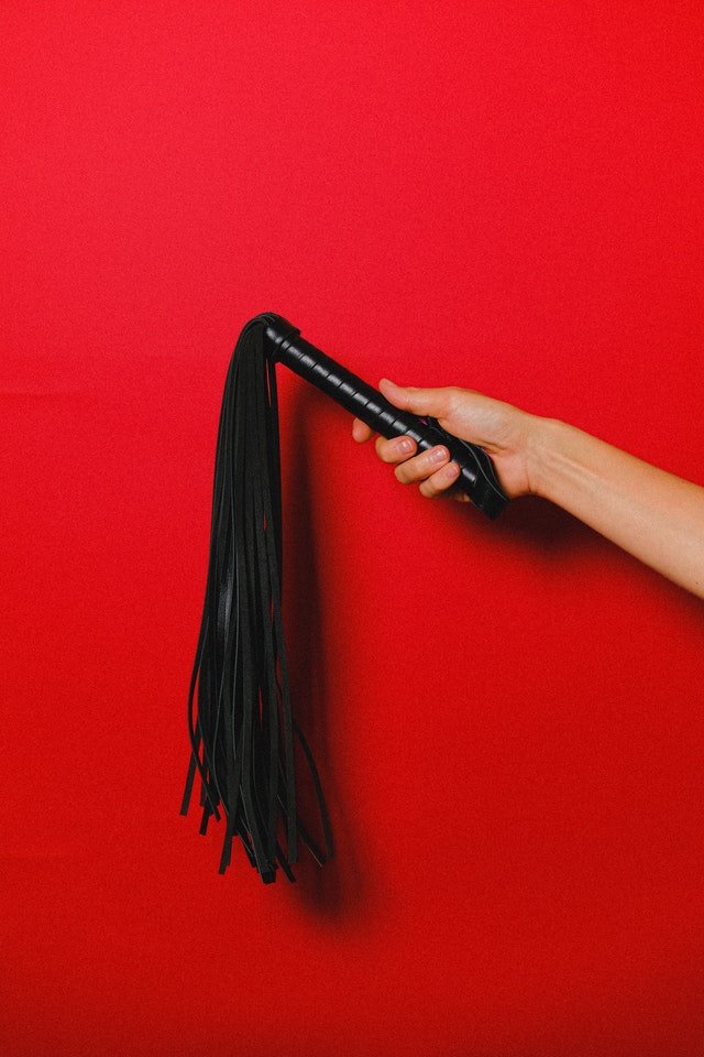 Image of flogger over red background