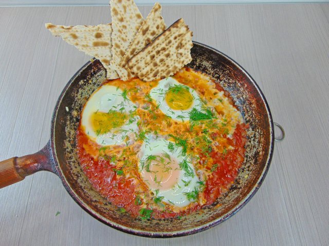Delicate fried eggs in juicy tomato sauce. Which is called shakshuka ...