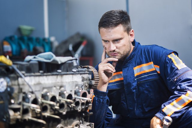 professional-experienced-car-mechanic-repairman-uniform-thinking-about-solution-looking-car-engine-m