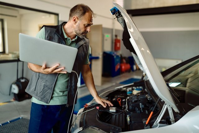 auto-repairman-using-laptop-while-examining-car-engine-workshop-min-Easy-Resize-com.jpg