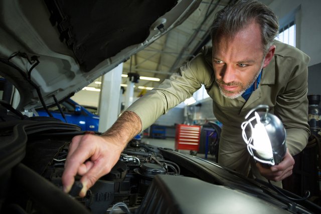 mechanic-examining-car-with-lamp-1.jpg