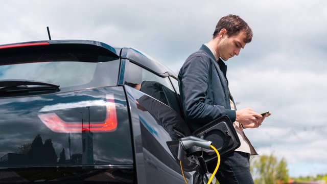 man-charging-his-electric-car-charge-station-using-smartphone-1.jpg