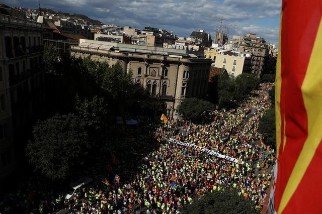 A banner reading "Independence Now" is carried as thousands of people gather for a rally on Catalonia's national day 'La Diada' in Barcelona
