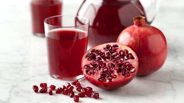 a pomegranate cut open, and pomegranate juice
