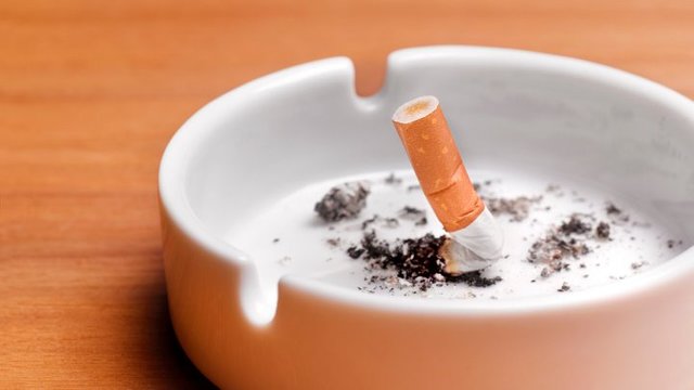 a cigarette stubbed out in an ashtray, representing quitting smoking