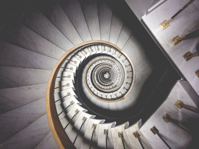 Impressive view down a stairwell with spiral marble stairs