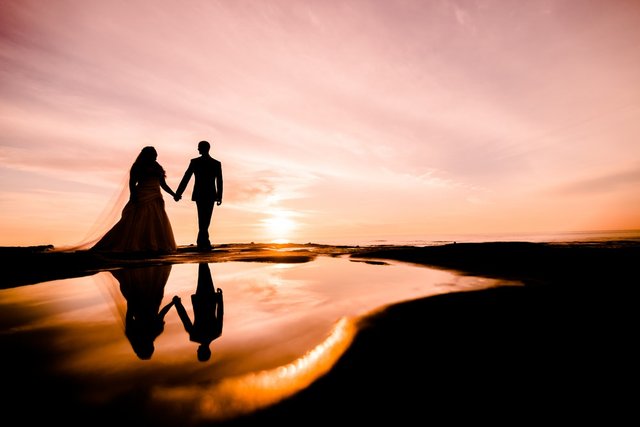silhouette of male and female while holding hands