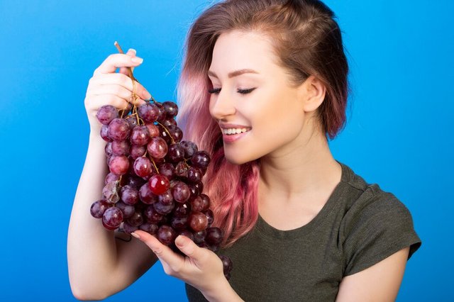 happy-woman-holds-big-bunch-grapes-with-both-hands_141793-1077.jpg