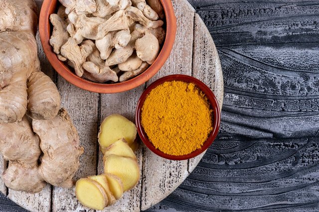 set-ginger-slices-powder-ginger-bowls-wood-dark-wooden-background-top-view_176474-1726.jpg