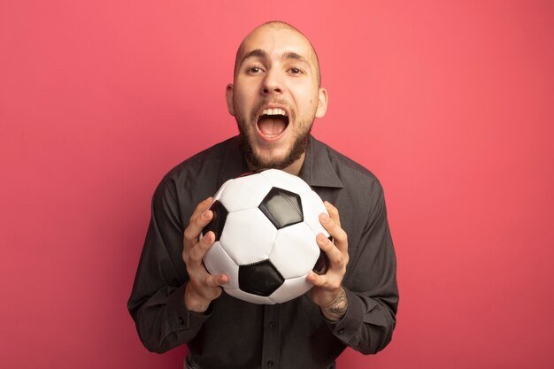 Free photo angry young handsome guy holding ball