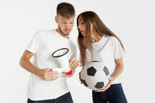 Free photo portrait of beautiful young couple football or soccer fans on white  space. facial expression, human emotions, advertising, sport concept