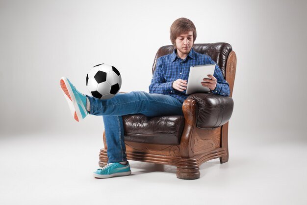 Free photo portrait of young man with laptop and football ball