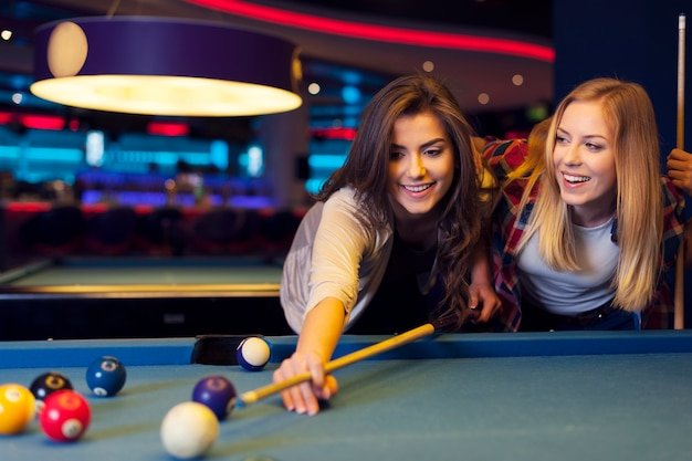 Free photo two female friends enjoying pool game