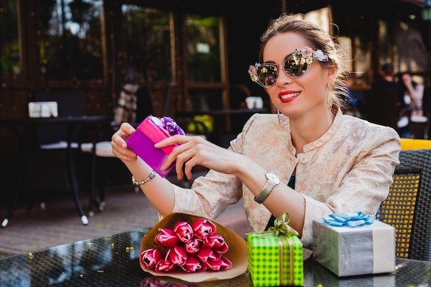 Free photo young stylish beautiful woman in fashion sunglasses sitting at cafe