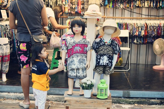 Two child manikins have a visit from a curious admirer