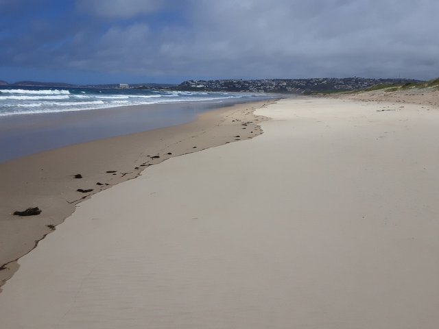 Soft clean white sand (with ony river grass from the lagoon), as far as the eye can see