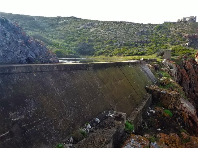 The dam wall containing the fresh spring water flowing down to the shore on the estate below the castle