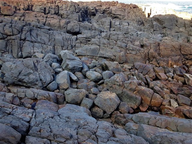 Here the ochre color of the rock has been temporarily covered over by dried sea foam that washes up during rougher swells