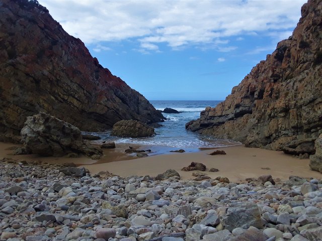 Idyllic little swimming channel, with rare endangered Black Oystercatcher birds at the water’s edge