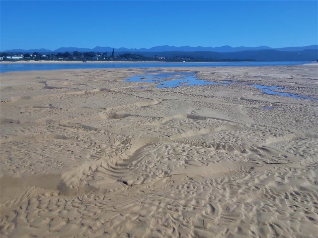 Lagoon in the middle ground with part of the town behind it, from the beach