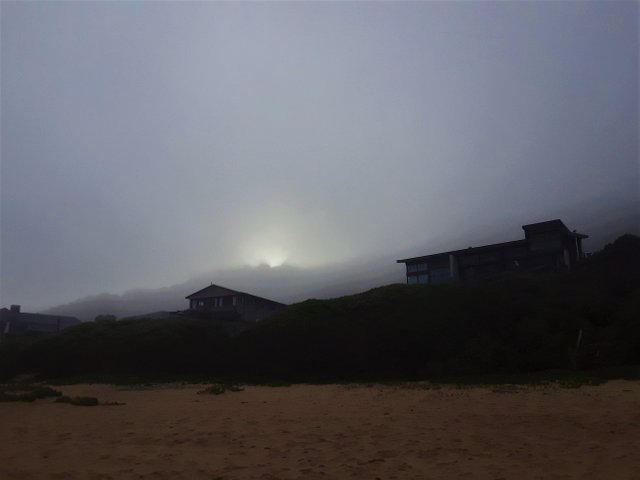 Late afternoon sun setting behind the hillside that overlooks the coastline